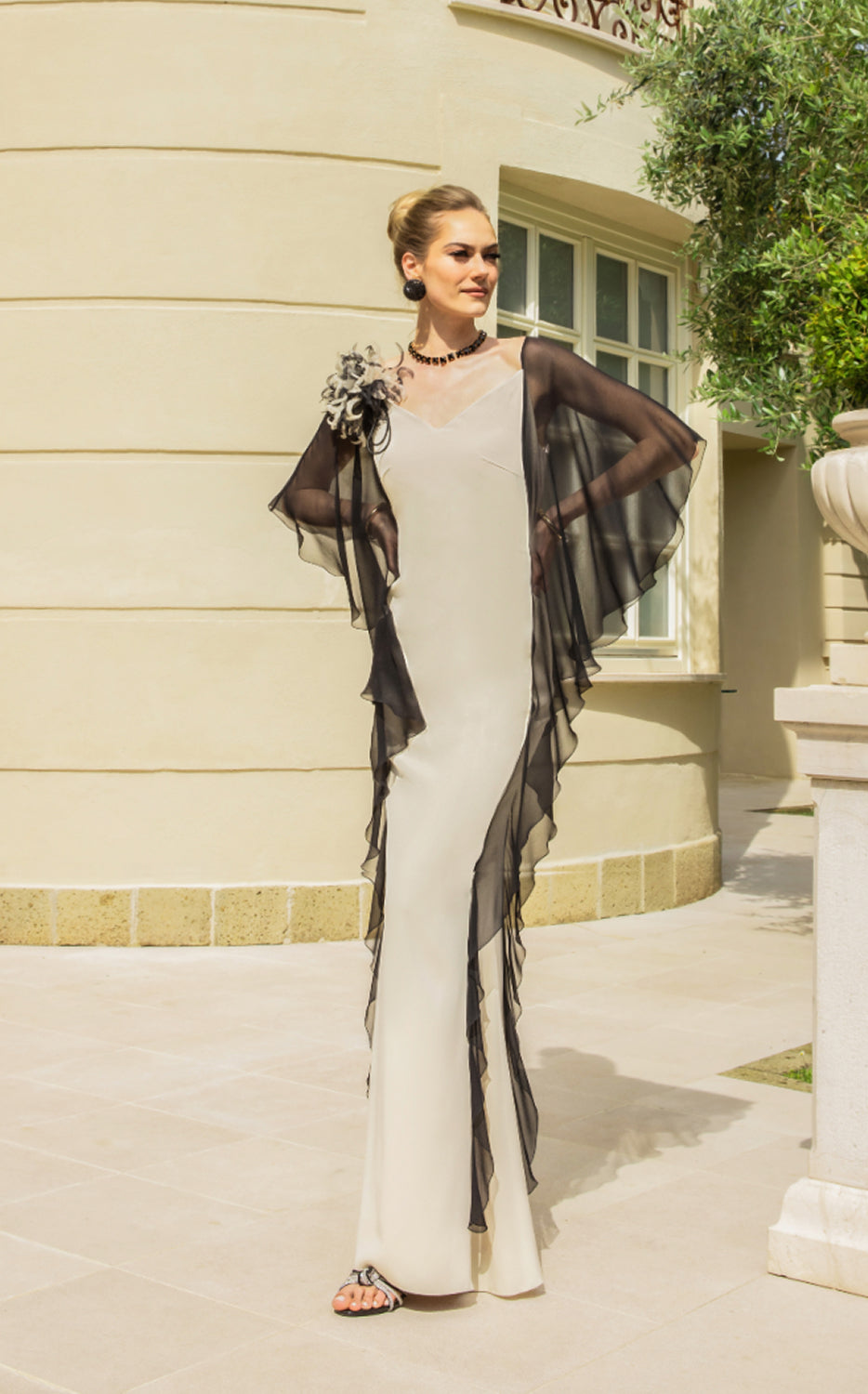 Abito lungo avorio con mantella nera e applicazione floreale